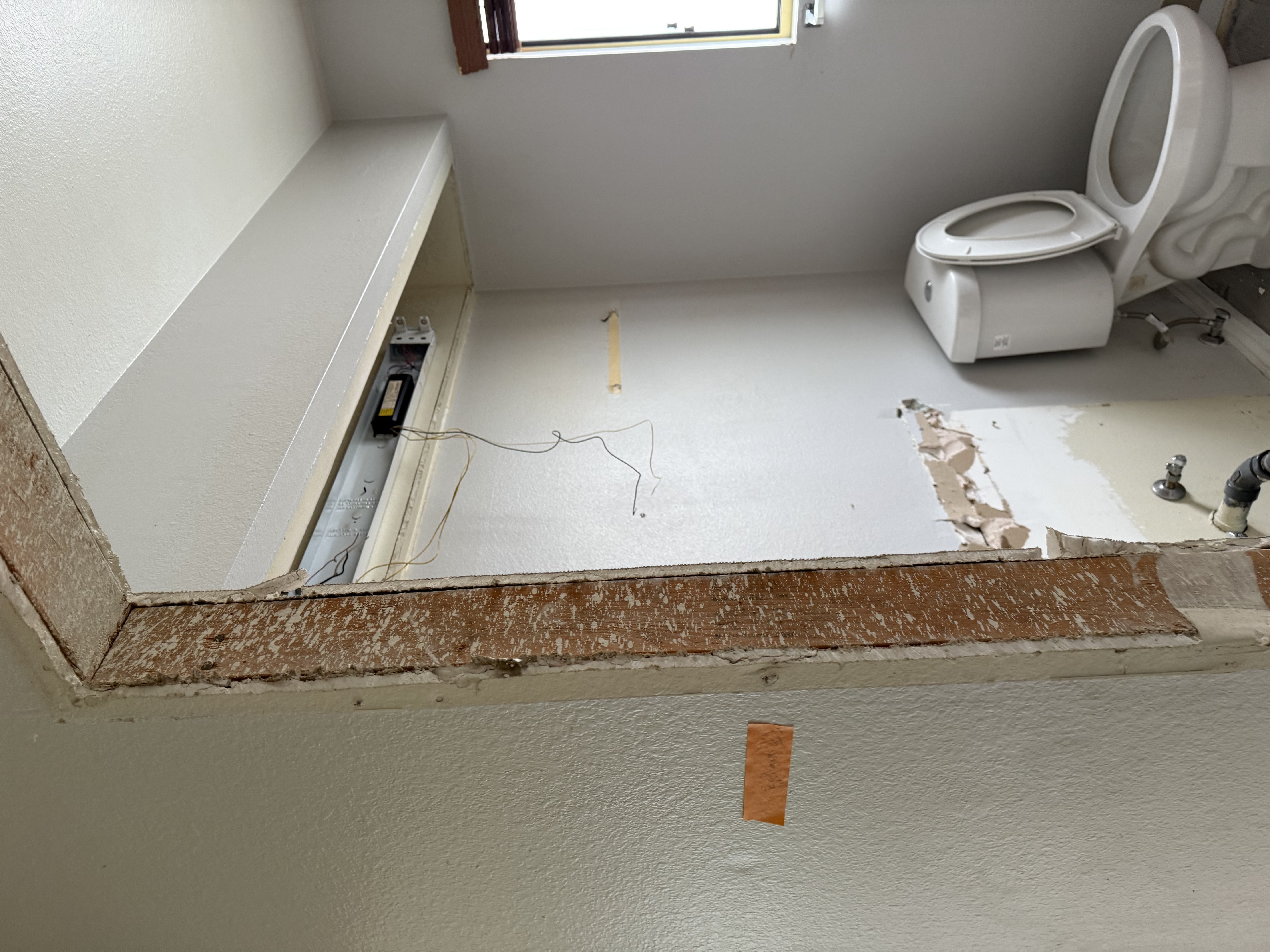 Water-damaged bathroom with drywall and tile removed, revealing saturated framing that requires structural drying